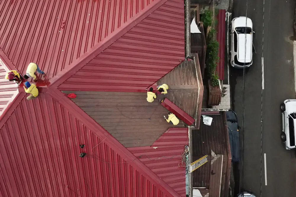 Aerial view of crew on a red metal roof