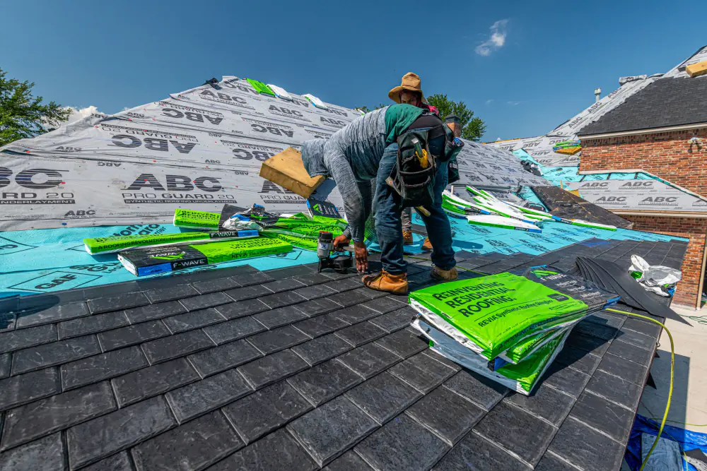 Crew on a roof with underlayment and shingles in progress